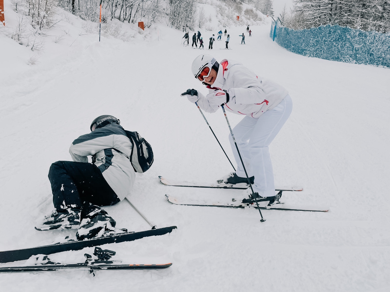 Two skiers sitting in the snow talking